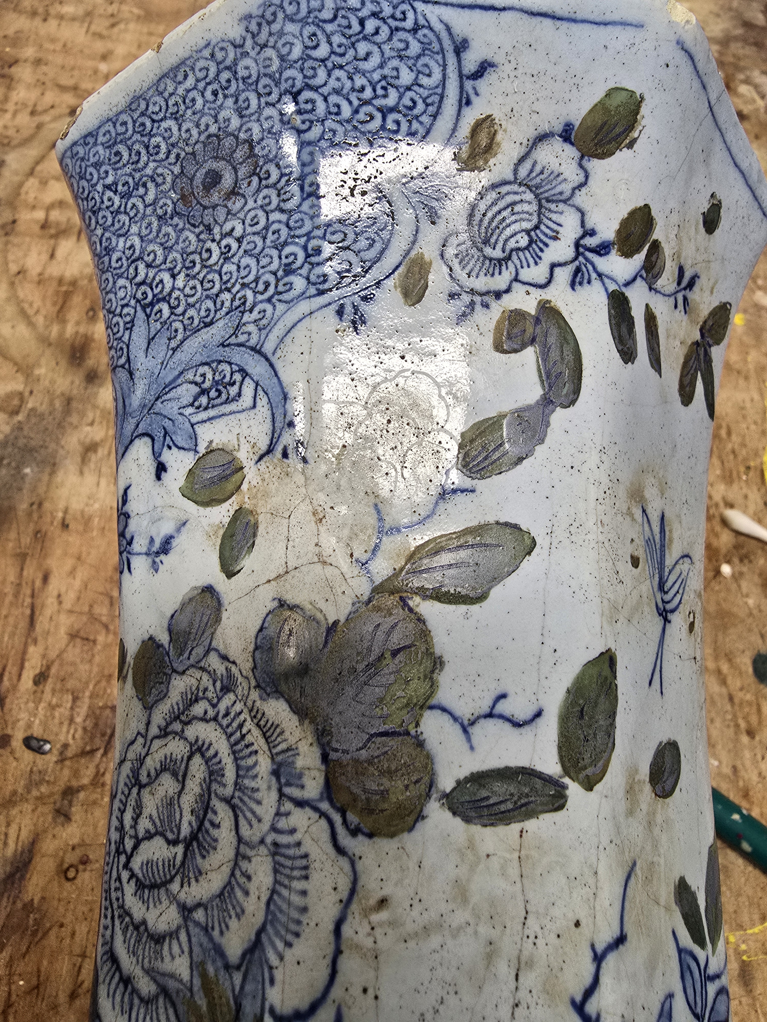Maar hier is de vage contouren van een bloem te zien met een blauw geglazuurde steel en bladeren, dus de bloem moet wel gepland zijn geweest.