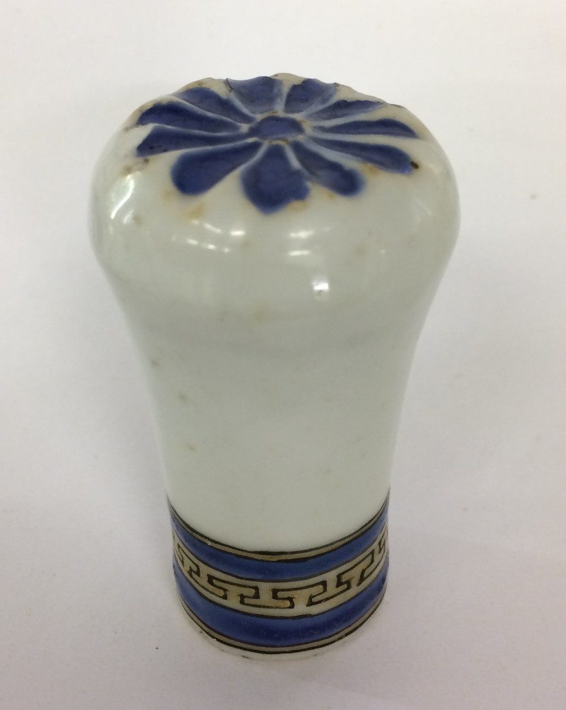 Photo. The walking stick knob is white with a blue floral motif on top.