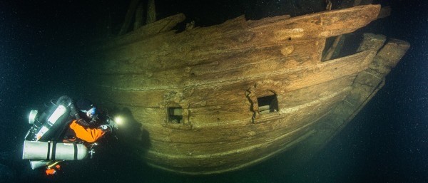 Een duiker naast een gezonken schip tijdens een expeditie